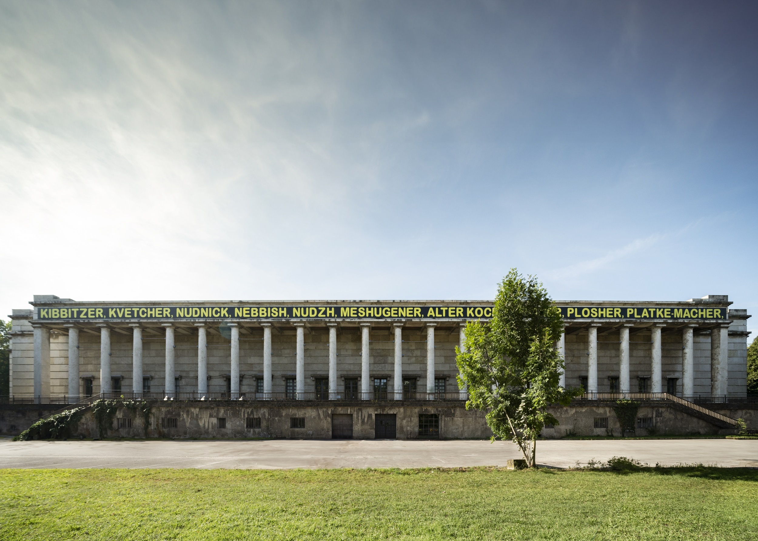 Large building with columns and letterings above them.