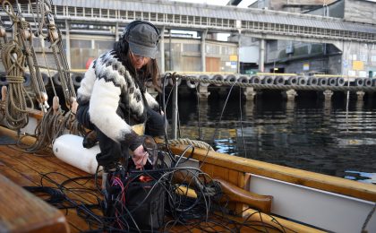 Eine Frau mit einem Mikrofon auf einem Boot.