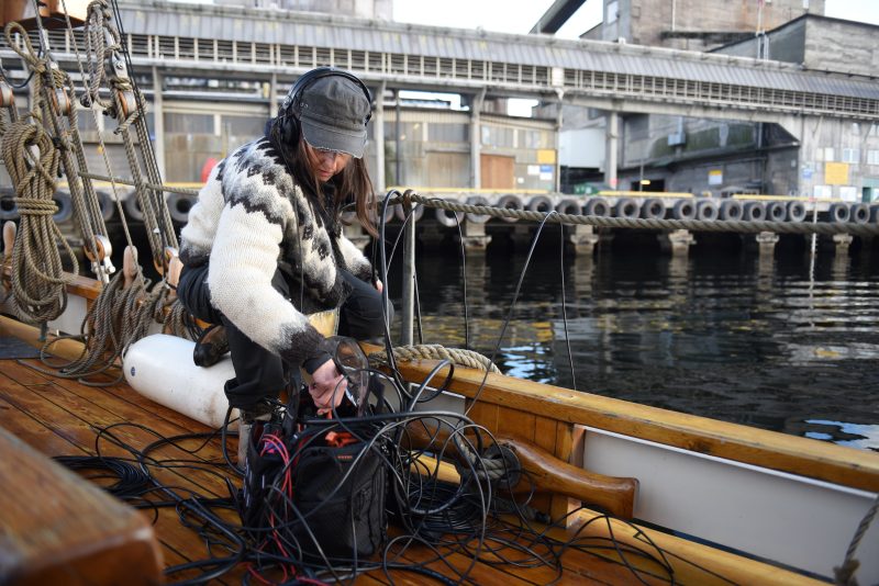 Eine Frau mit einem Mikrofon auf einem Boot.